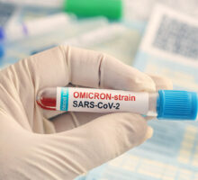 Doctor holding test tube labeled Omicron